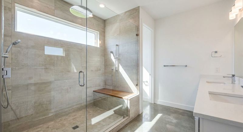 Walk-in shower with frameless glass and rainfall showerhead by Trini Homes in Gainesville FL