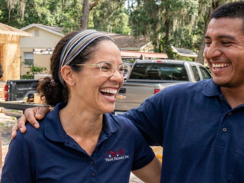 Owner Mary Ann laughing with the Trini Homes crew on a Gainesville FL job site